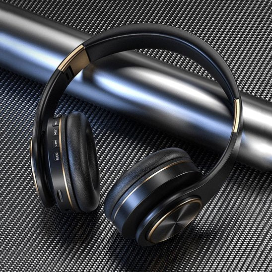 Casque Bluetooth noir posé près d’un haut-parleur moderne