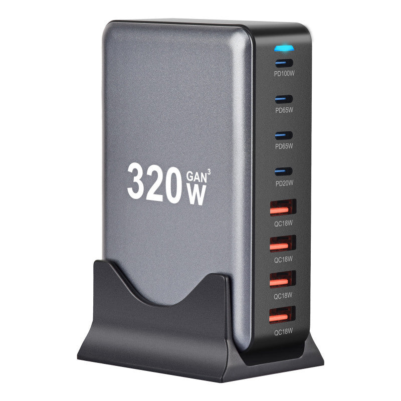 Chargeur universel 320W GaN avec 8 ports USB-C et USB-A placé verticalement sur son support, indicateur LED bleu allumé