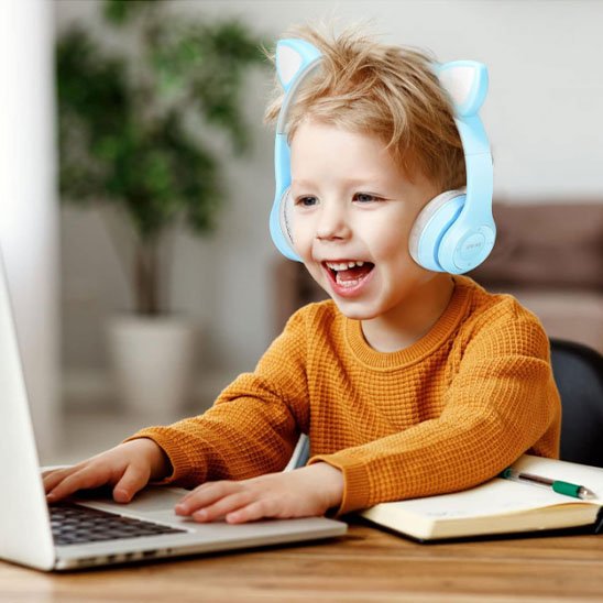 Garçon avec casque sans fil bleu sur portable