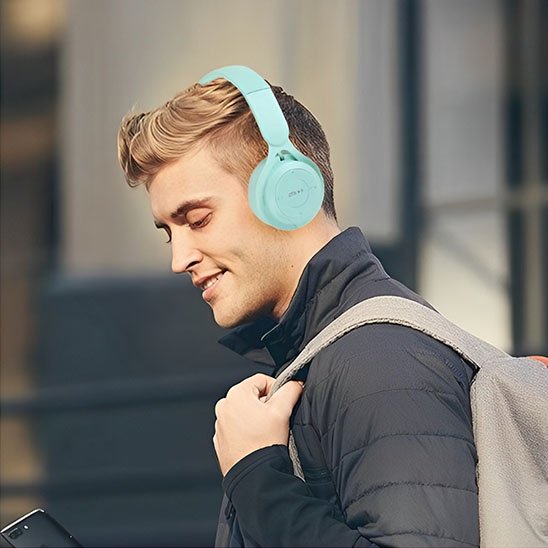 Jeune homme utilisant un casque Bluetooth bleu en extérieur