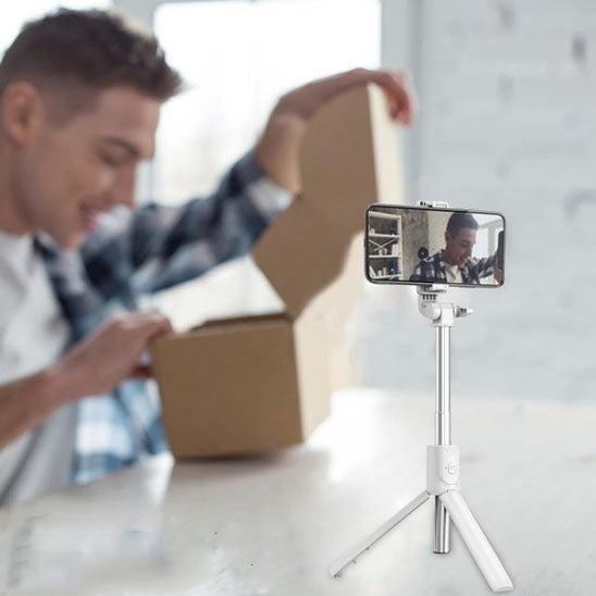Perche à selfie blanche avec support pour téléphone, idéale pour filmer le déballage de produits, le vlogging ou la création de contenu à la maison.