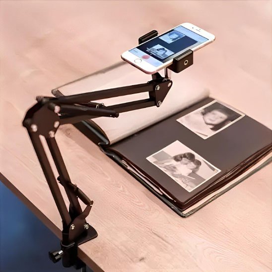 Support articulé pour smartphone fixé à une table, utilisé pour numériser un album photo avec des clichés en noir et blanc